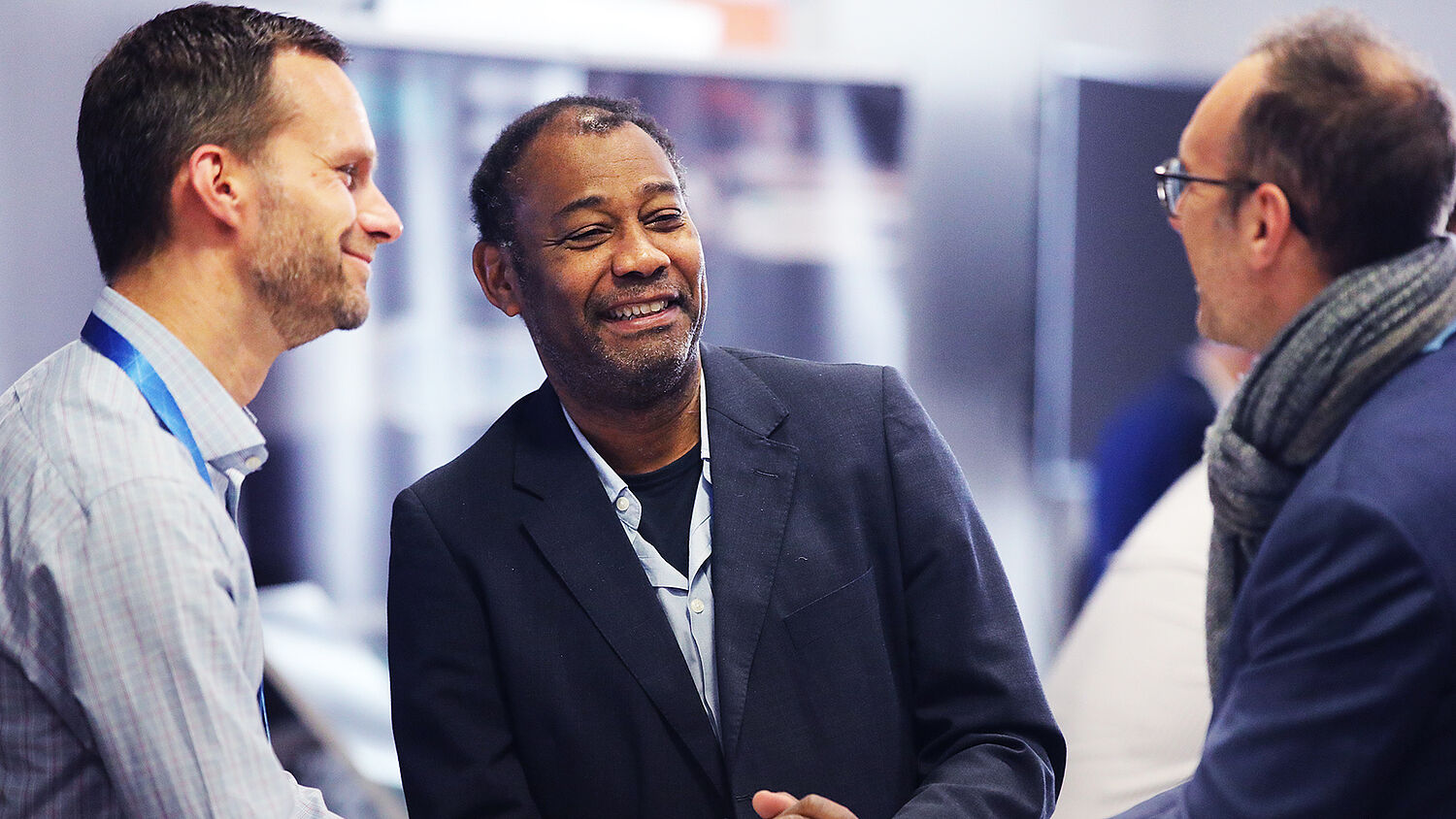 Three participants networking during break at the Automotive Computing Conference 2025