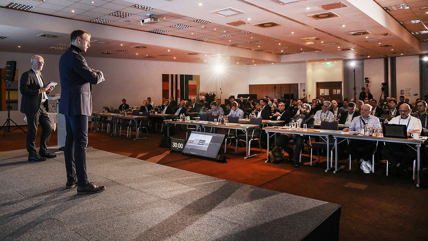Dr. Sergey Tverdyshev speaking in front of the audience at the ACC 2025